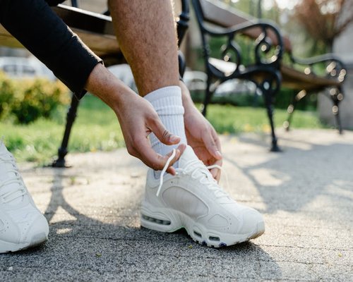 Person tying shoelaces preparing for a morning walk